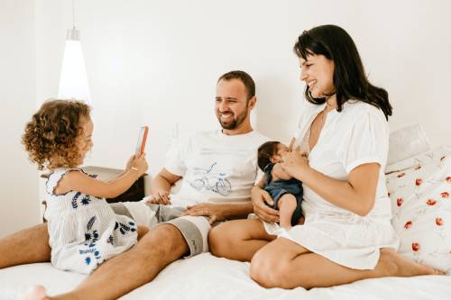 deux parents avec leur enfant sur le lit 