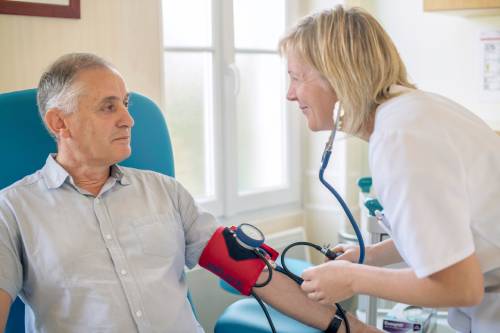 Infimière qui prend la tension à un patient