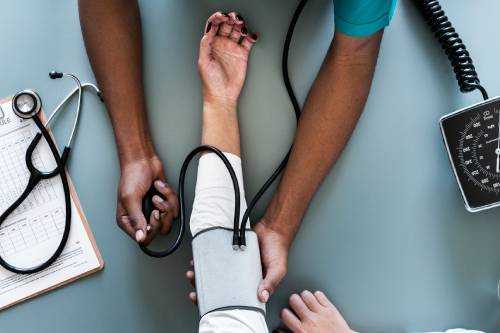 Homme qui prend la tension à un patient